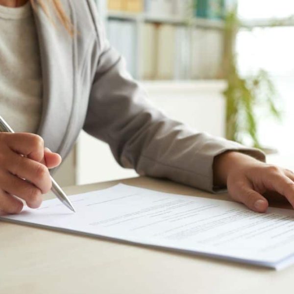 Une femme en costume signe un contrat